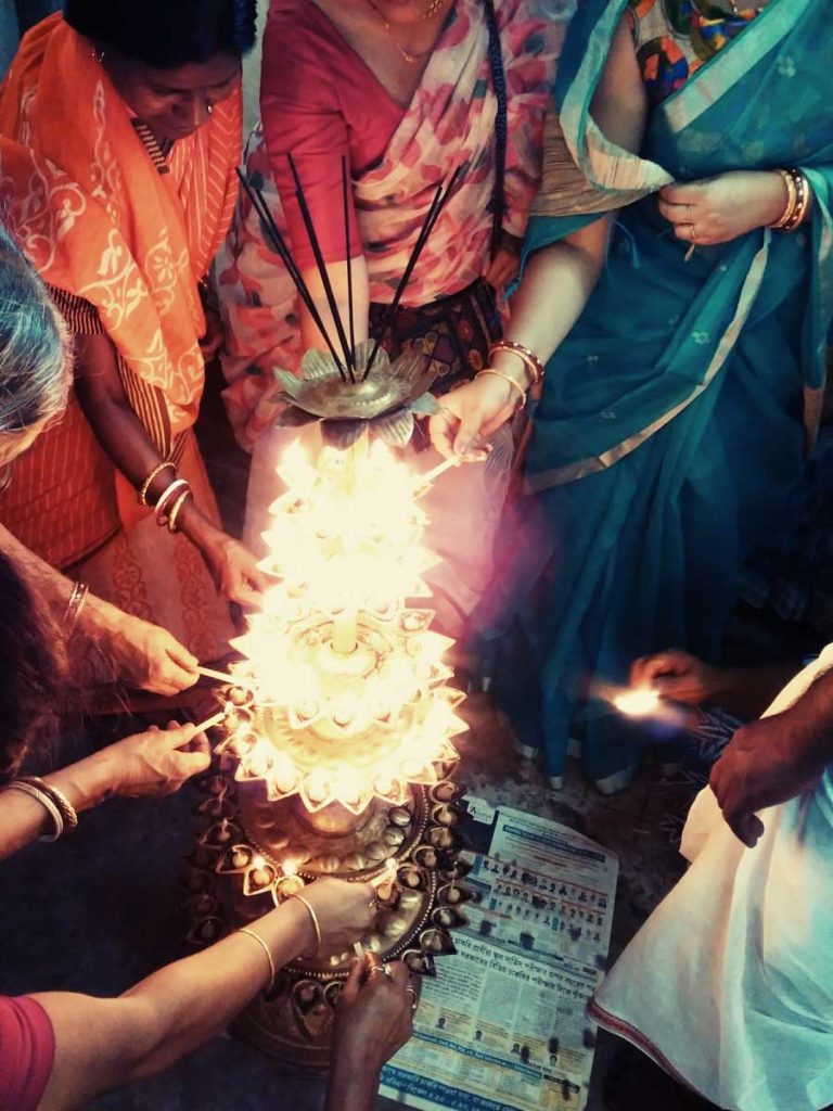 lighting 108 diyas during Durga Puja